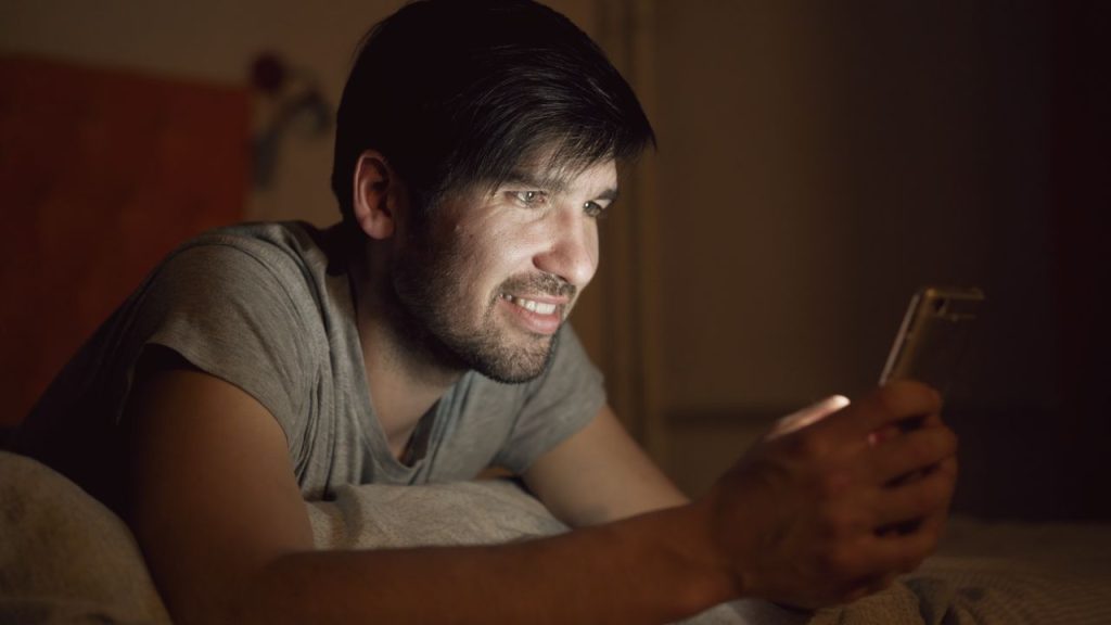 pexels photo 36698027 36698027 A man enjoys a late-night phone screen, illuminating his face.