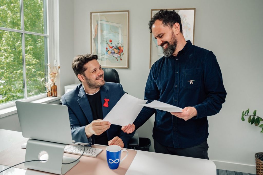 Two business professionals discussing documents in a bright, modern office setting.